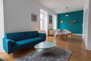 リスボンにあるSunny 3BDR Apartment in Graça by LovelyStayのリビングルーム(青いソファ、テーブル付)