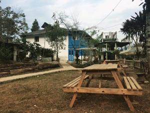 a picnic table in front of a blue house at Temi Kothi Homestay in Temi