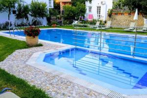 a swimming pool with blue water in a yard at Katerina's apartments in Agios Gordios +6 photos