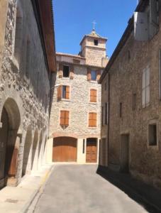 an alley in an old building with a tower at Chambre du Puits du Couvent in Narbonne +19 photos