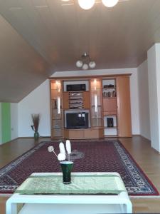 a living room with a table and a kitchen at Ferienwohnung Wagner in Zweibrücken