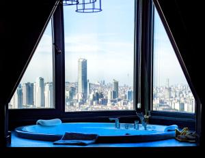 a bathroom with a blue tub in front of a window at Cityloft 161 in Istanbul