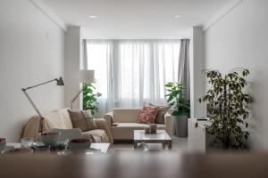 a living room with a couch and two potted plants at Light-Filled, Fully Renovated Apt near Belém, By TimeCooler in Lisbon