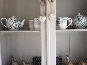 a shelf with vases and cups on it at fleur de garance in Le Thor