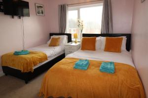 1 dormitorio con 2 camas y toallas. en Dryden House, en Chesterfield