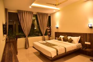 a bedroom with a bed and a window at Le Oak Inn in Mysore