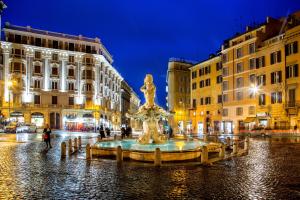 une fontaine au milieu d'une ville la nuit dans l'établissement Well Done Montebello, à Rome