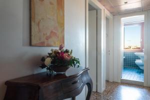 La salle de bains est pourvue d'une table et d'un vase de fleurs. dans l'établissement Locanda Ai Santi Apostoli, à Venise