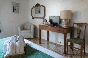 a bedroom with a desk with a television and a chair at Locanda Ai Santi Apostoli in Venice