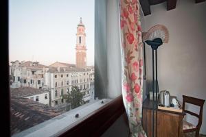 a window with a view of a city with a clock tower at Locanda Ai Santi Apostoli in Venice