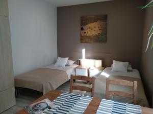 2 łóżka w pokoju ze stołem i krzesłami w obiekcie City Apartments & Gym we Wrocławiu