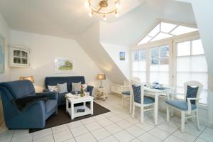 a living room with blue furniture and a table at App-Syltperle in Westerland (Sylt)