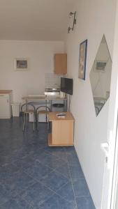 una cocina con mesa, sillas y mesa y una habitación en Apartmani Herceg en Karlobag