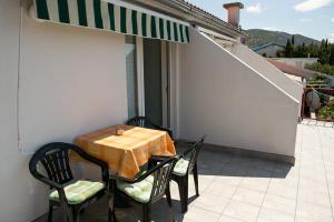 a table and chairs on the balcony of a house at Apartmani Herceg in Karlobag