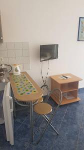 Una mesa y una silla en una cocina con TV. en Apartmani Herceg en Karlobag