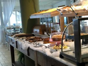 una línea de buffet con diferentes tipos de pasteles y repostería en Flat Summer, en Florianópolis