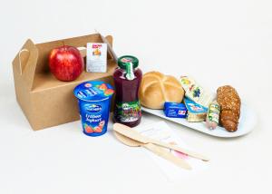 eine Schachtel mit Lebensmitteln und einem Apfel und einem Teller mit Lebensmitteln in der Unterkunft Pension Leuprecht in Reutte