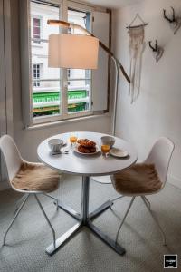 einem weißen Tisch mit einem Teller mit Lebensmitteln und einer Lampe in der Unterkunft Ma Poésie - Charme & emplacement idéal in Honfleur