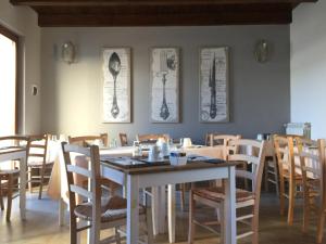 a dining room with a white table and chairs at Il Casale Del Giglio in Santo Stefano di Magra