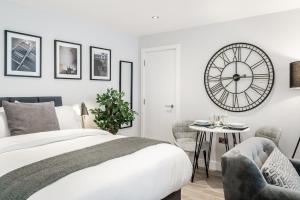 a bedroom with a bed and a large clock on the wall at Tailored Stays - Central Cambridge Studios, Free Parking in Cambridge