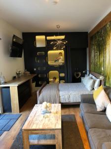温莎Willow Court Farm Studio West & Petting Farm, 8 mins to Legoland & Windsor, 15 mins to Lapland UK的带床和沙发的客厅