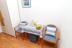 einen Tisch mit zwei Stühlen und eine Schale Obst darauf in der Unterkunft Guest House Franica & Pero Lobrovic in Slano