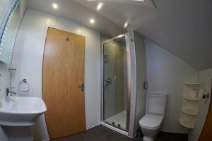 a bathroom with a sink and a toilet and a shower at Karrawa Guest House in Kirkwall +26 photos