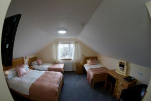 Habitación de hotel con 2 camas y ventana en Karrawa Guest House, en Kirkwall