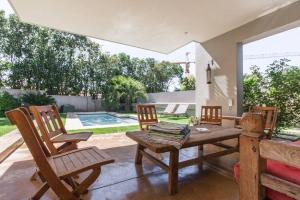un patio con mesa, sillas y piscina en Houghton Place en Johannesburgo
