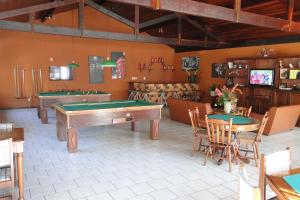 a room with two pool tables and chairs and a room with tablesktop at Hotel dos Bretões in Sapucaia