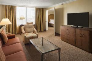 a living room with a couch and a flat screen tv at Crowne Plaza Louisville Airport Expo Center, an IHG Hotel in Louisville