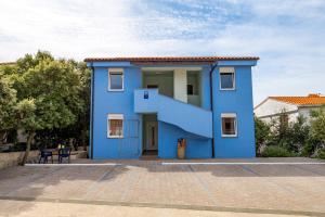 une maison bleue avec un escalier en face de celle-ci dans l'établissement Modra Kuca, à Mandre