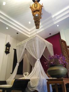 a room with a curtain and a chandelier at Ruean Thai Hotel in Sukhothai