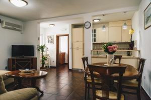 sala de estar con mesa y cocina en El Mar Apartments, en Budva