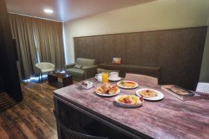 a table with two plates of food on it at Urban Suites Apart Hotel in Santa Cruz de la Sierra