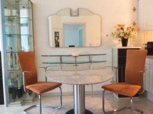 einen Tisch und zwei Stühle in einem Zimmer mit Spiegel in der Unterkunft Ferien-Appartement am Schloßsee in Salem