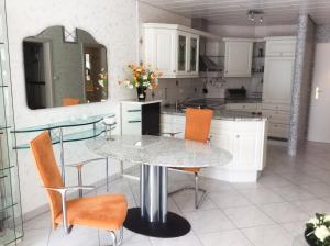 eine Küche mit einem Tisch, Stühlen und einem Spiegel in der Unterkunft Ferien-Appartement am Schloßsee in Salem