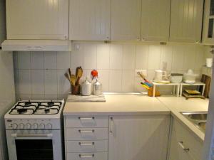 a white kitchen with a stove and a sink at Casa Schlatter in Florence