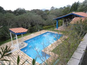 a swimming pool with a gazebo in a garden at Casa Campo Tipo Fazenda in Mairinque