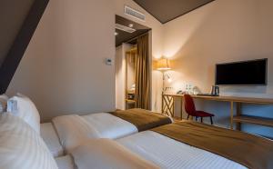 Rúm í herbergi á Gladius Inn Boutique Hotel by DNT Group
