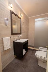 a bathroom with a sink and a toilet and a mirror at Hotel Rivoli in Mar del Plata