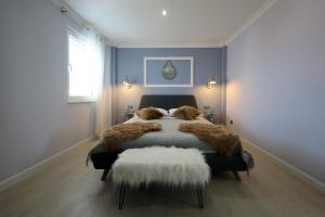 een slaapkamer met een bed met een getufte sprei en een behang bij Villa DOEL in Zadar