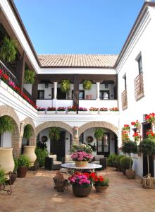a large building with a bunch of flowers in front of it at Suites La Posada De Pilar in Córdoba