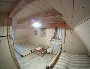 ein Zimmer mit einem Bett und einem Sofa im Dachgeschoss in der Unterkunft Drevenica pod orechom in Detva