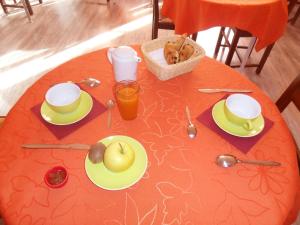 stół z pomarańczową tkaniną i jabłkiem w obiekcie Chambres d'hôtes d'Accolay w mieście Accolay