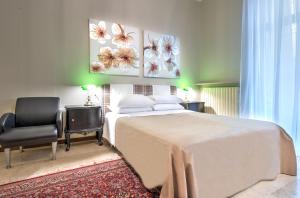 a bedroom with a large white bed and a chair at Ramé Suites in Bergamo