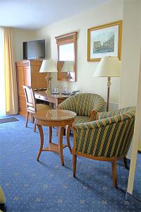 a hotel room with a couch and a table and chairs at Hotel zur Schwaben-Schänke in Renningen