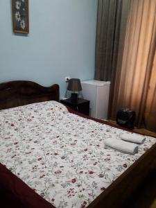 a bedroom with a bed with a flowered bedspread with aperature at Hotel Newland in Chiatʼura