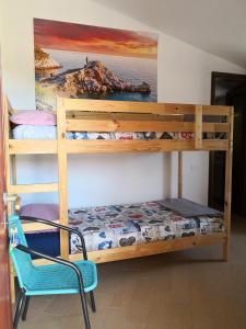 una camera con letto a castello e sedia di Il nido dei Gabbiani a Portovenere