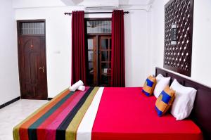 ein Schlafzimmer mit einem Bett mit einer bunten Decke in der Unterkunft Myr-o Homestay in Anuradhapura